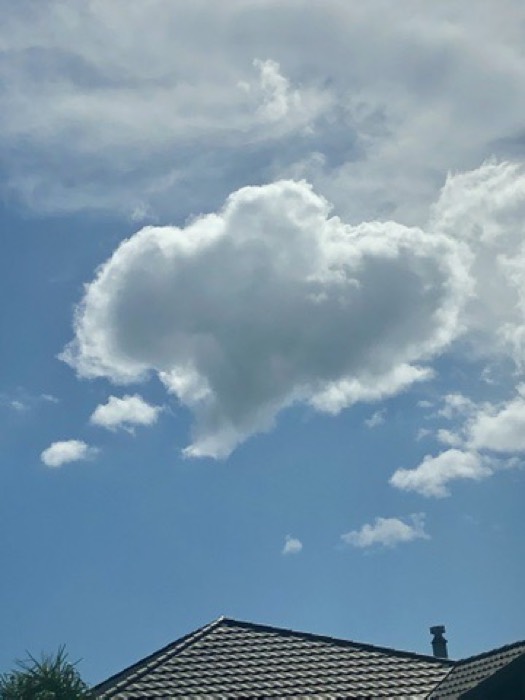 Herzförmige Wolke am blauen Himmel